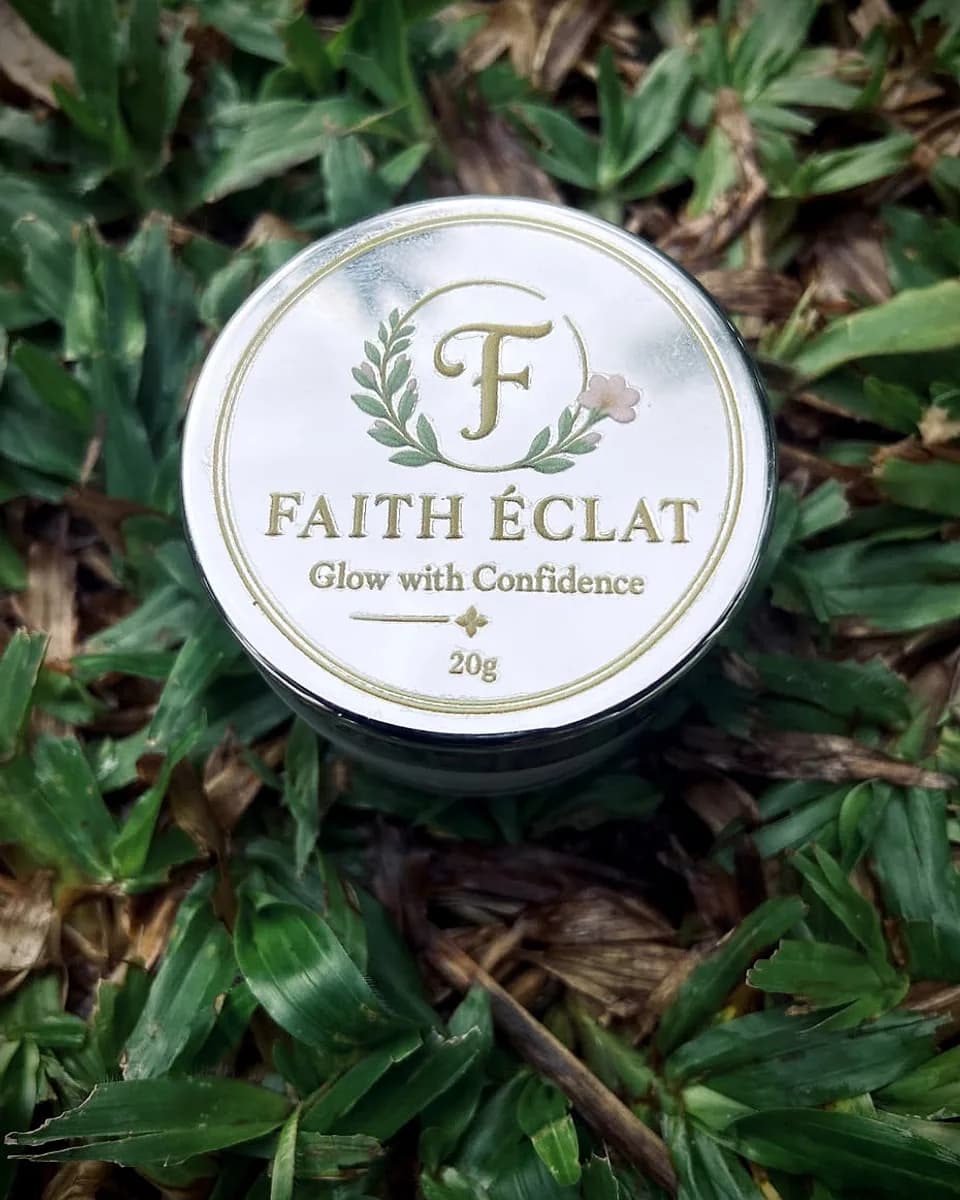 Faith Éclat Glow Cream jar, closed, resting on natural grass