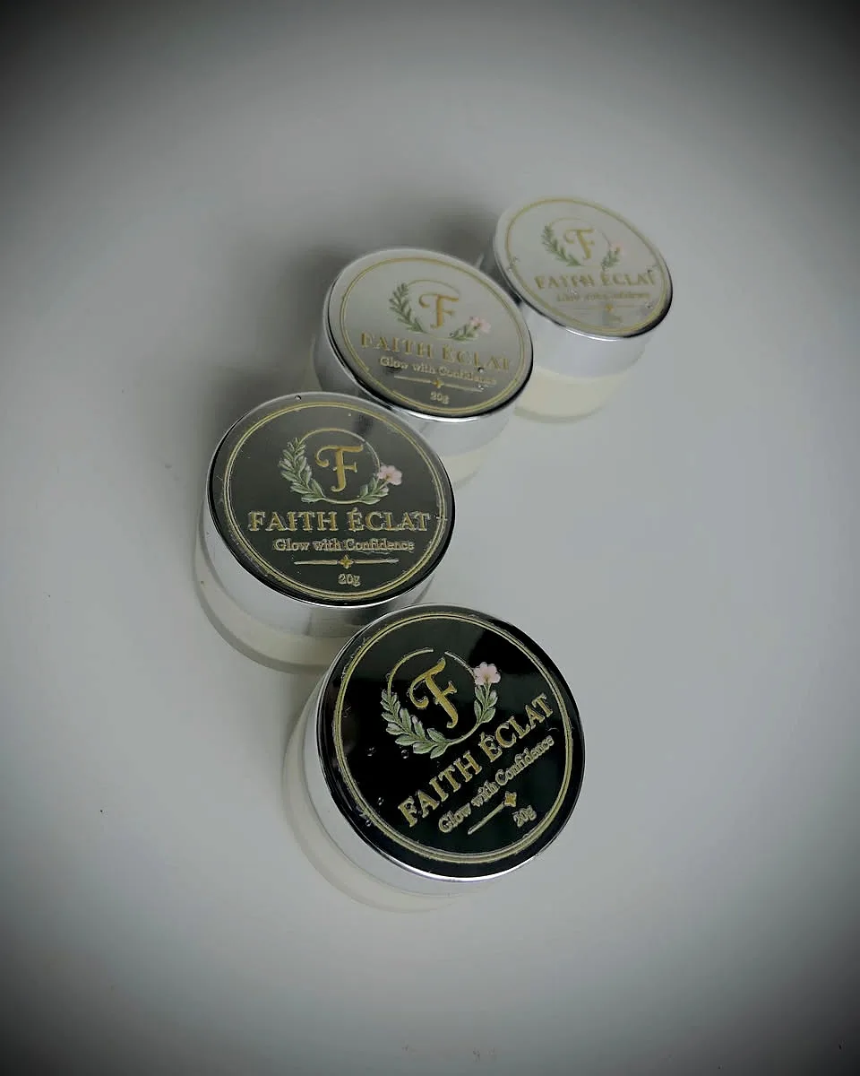 Four Faith Éclat Glow Cream jars in silver and black lid finishes