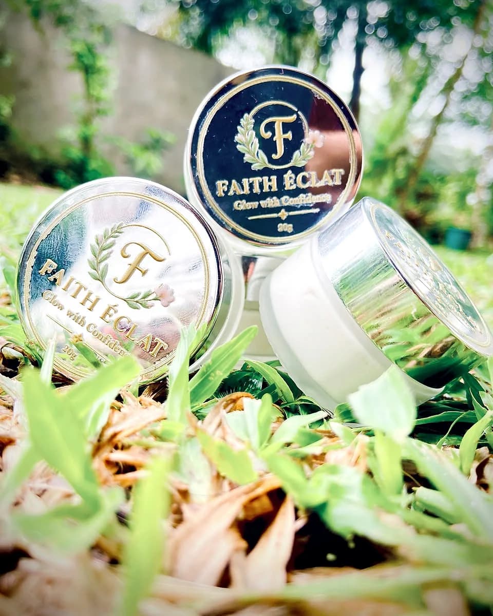 Faith Éclat Glow Cream jars styled outdoors among greenery